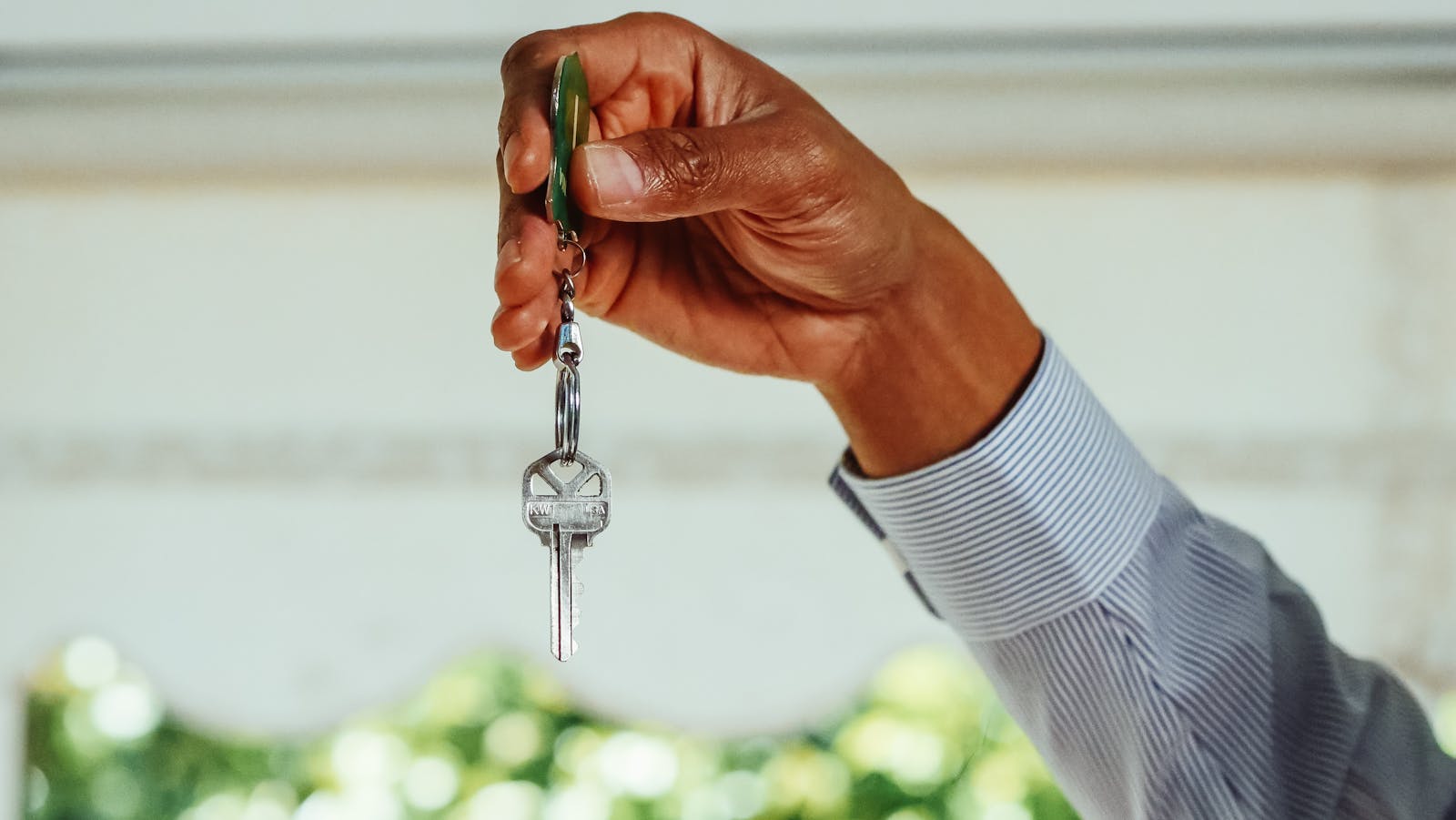 renter, a hand holding a set of house keys, symbolizing buying or renting a new home.